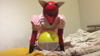 Gummi / LAtex Fuchs Mädchen spielt mit Wasserball auf dem Bett